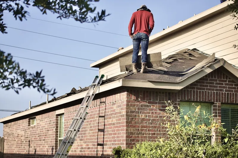 Professional roofer working on a residential roof in Bethalto
